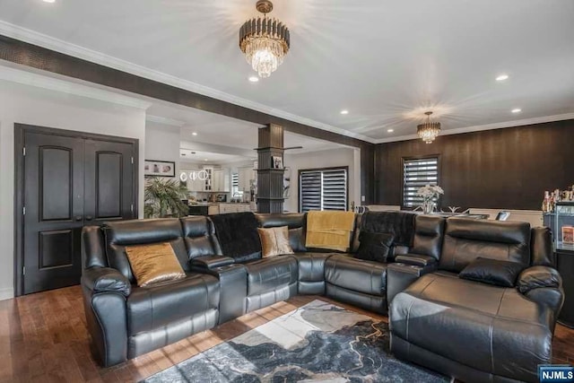 cinema with hardwood / wood-style floors, crown molding, and a notable chandelier