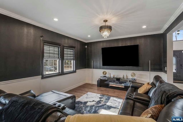 living room with a notable chandelier, wood-type flooring, and crown molding