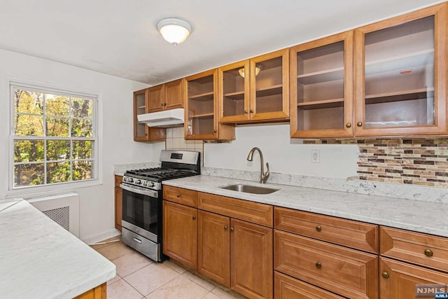 kitchen with light stone countertops, sink, tasteful backsplash, stainless steel gas range oven, and light tile patterned floors