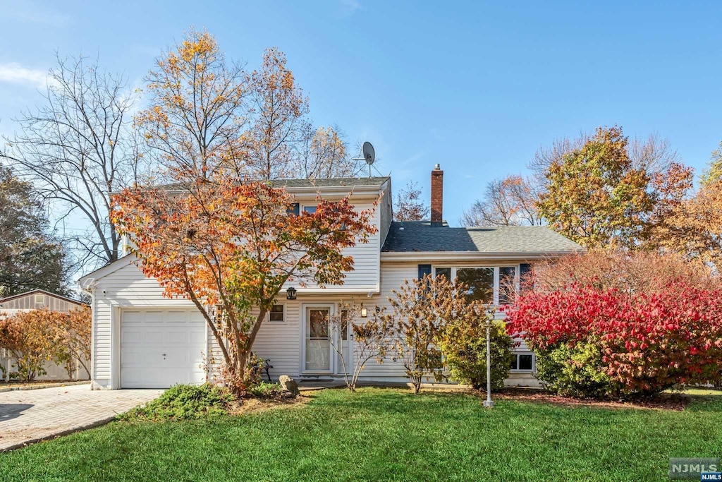 view of front of house featuring a front lawn and a garage