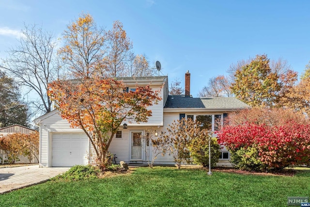 view of front of house featuring a front lawn and a garage