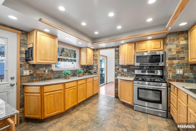 kitchen featuring backsplash, light stone countertops, and stainless steel appliances