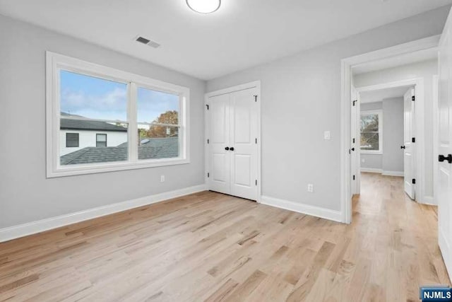 unfurnished bedroom with a closet and light hardwood / wood-style floors