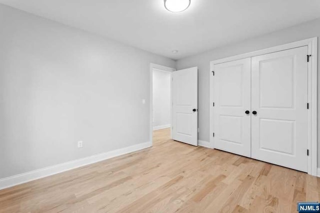 unfurnished bedroom featuring a closet and light hardwood / wood-style flooring