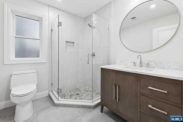 bathroom featuring tile patterned flooring, vanity, toilet, and a shower with door