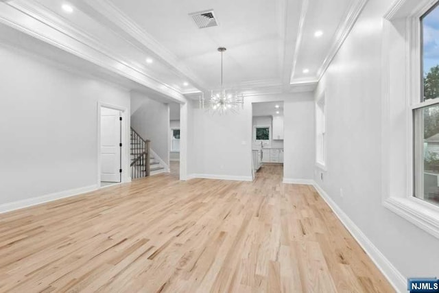 unfurnished living room with an inviting chandelier, light hardwood / wood-style flooring, and ornamental molding