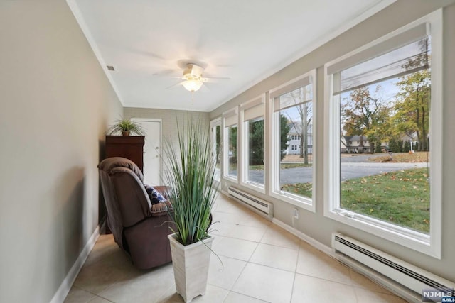 sunroom / solarium with ceiling fan, a healthy amount of sunlight, and a baseboard heating unit