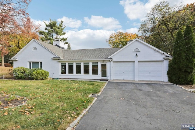 single story home with a garage and a front lawn