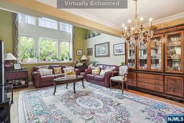 living room featuring hardwood / wood-style floors, a notable chandelier, and ornamental molding