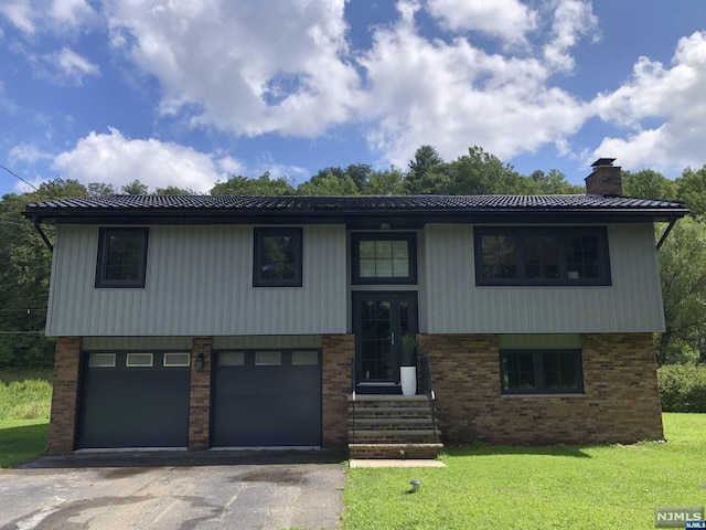 bi-level home with a garage and a front yard