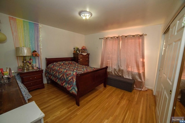 bedroom with light hardwood / wood-style flooring and a closet