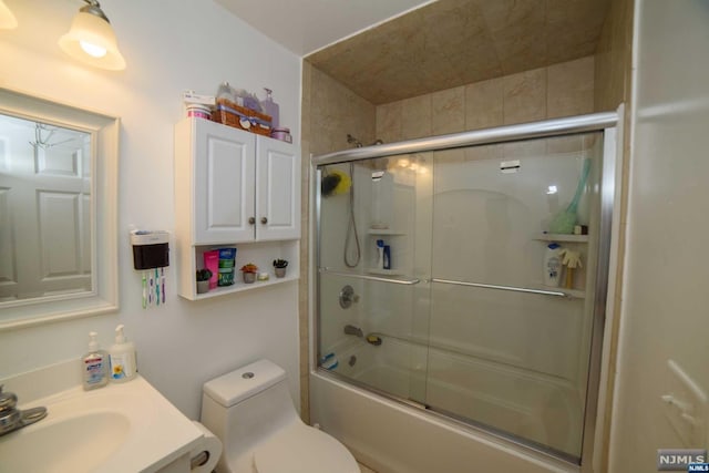 full bathroom featuring shower / bath combination with glass door, vanity, and toilet