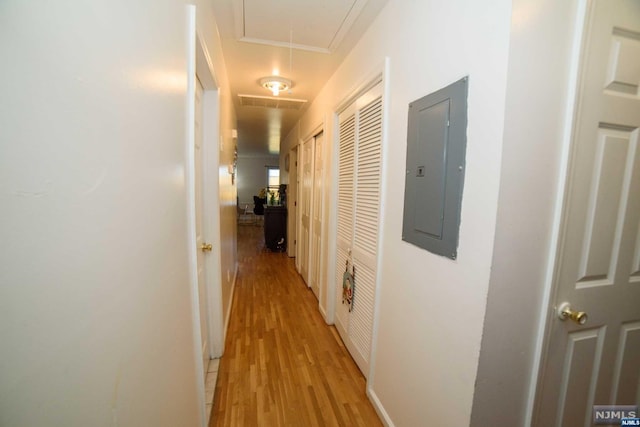 hallway with light hardwood / wood-style floors and electric panel