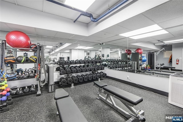 exercise room with a paneled ceiling