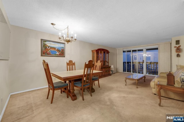 carpeted dining room with a chandelier and a textured ceiling