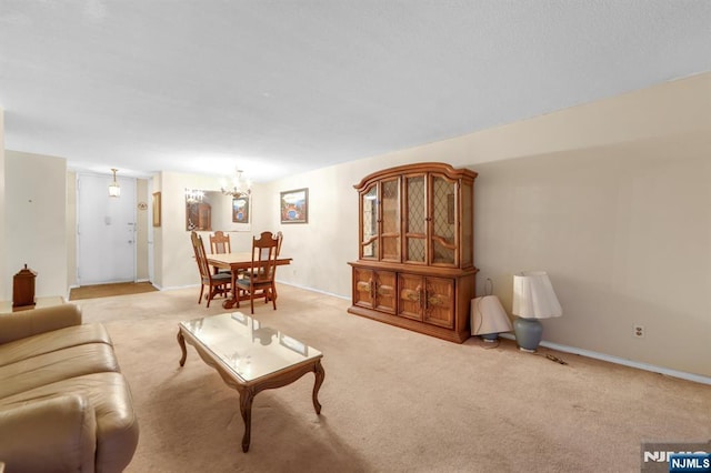 carpeted living room with a notable chandelier