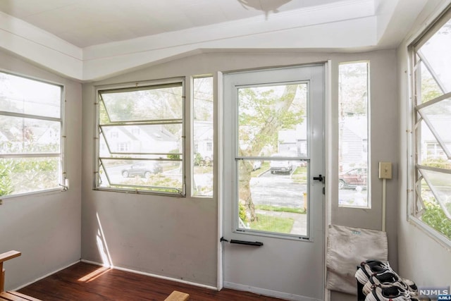 doorway with a healthy amount of sunlight, dark hardwood / wood-style flooring, and ornamental molding