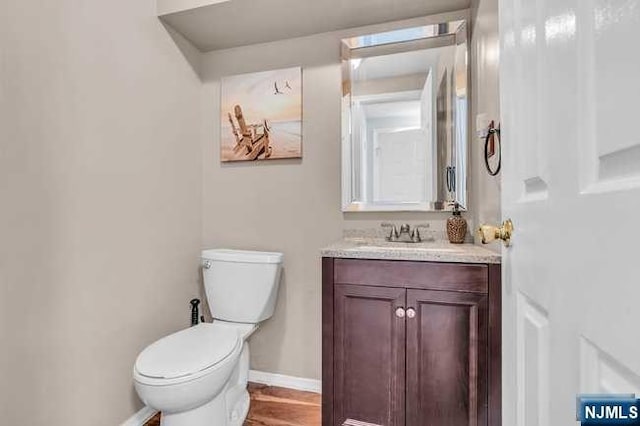 bathroom featuring vanity, hardwood / wood-style flooring, and toilet