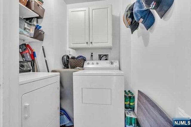 washroom featuring washer and dryer and cabinets