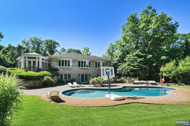 rear view of property featuring a patio area and a lawn