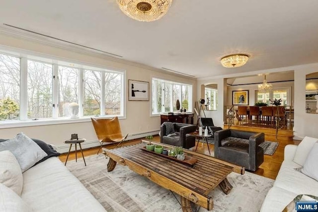 living room featuring wood-type flooring, ornamental molding, and a chandelier