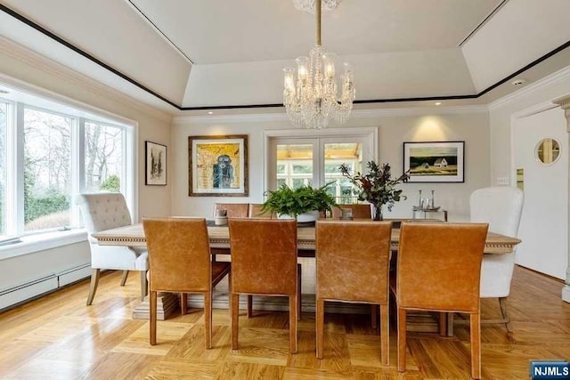 dining room with a raised ceiling, a healthy amount of sunlight, and a notable chandelier