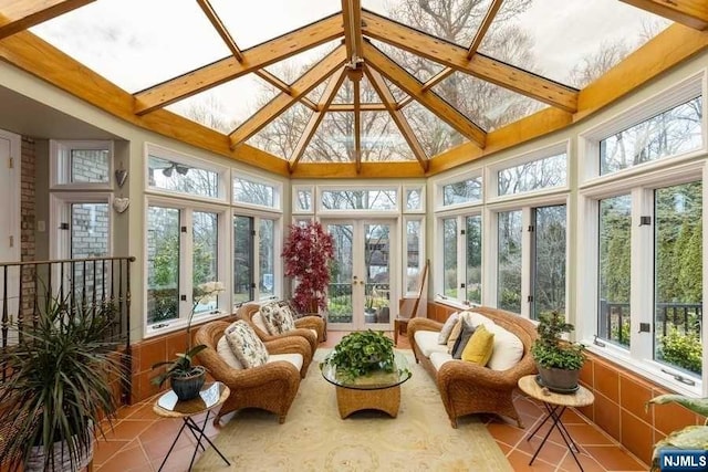 sunroom featuring lofted ceiling with beams and french doors