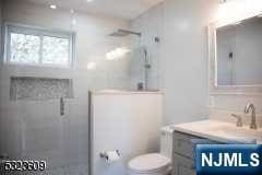 bathroom featuring vanity, toilet, and an enclosed shower