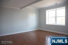 empty room featuring beamed ceiling and ornamental molding