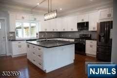 kitchen featuring white cabinetry, a center island, and black appliances