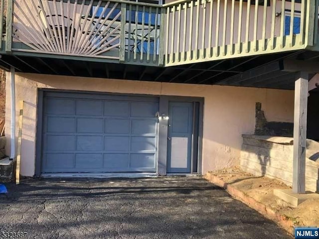 view of exterior entry featuring a balcony and a garage