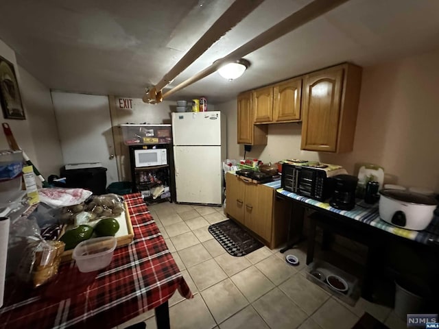 kitchen featuring light tile patterned flooring and white appliances