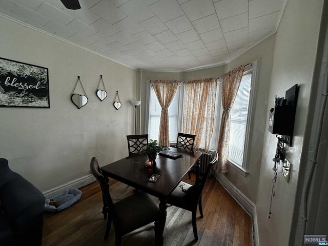 dining area featuring dark hardwood / wood-style floors and ornamental molding