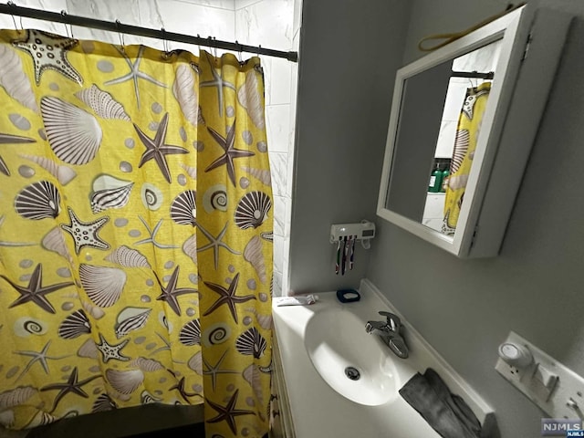 bathroom with curtained shower and sink