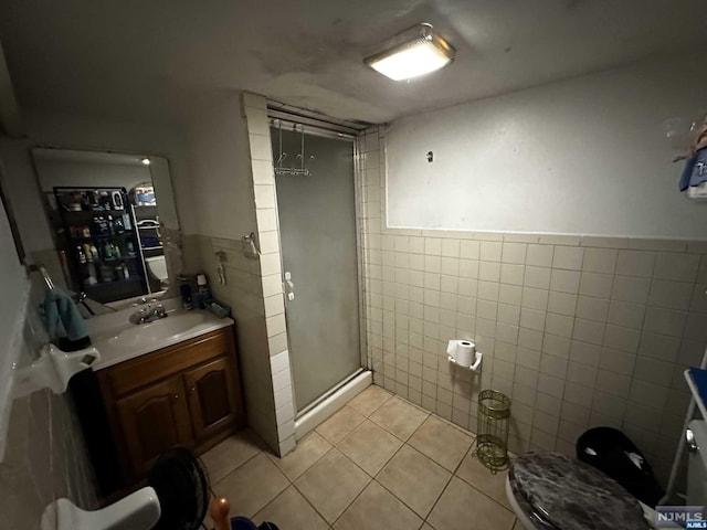 bathroom featuring vanity, tile patterned floors, toilet, walk in shower, and tile walls