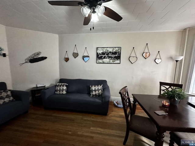 living room featuring ornamental molding, ceiling fan, and dark wood-type flooring