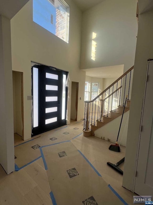 foyer entrance with a towering ceiling