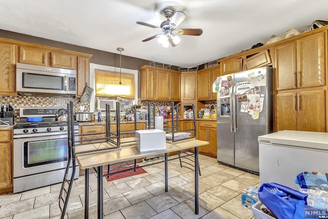 kitchen with decorative light fixtures, ceiling fan, backsplash, and appliances with stainless steel finishes