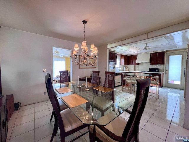 dining space featuring ceiling fan with notable chandelier and light tile patterned flooring