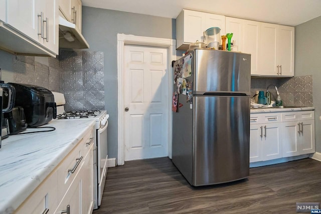 kitchen featuring white cabinets, dark hardwood / wood-style floors, stainless steel fridge, and white gas range oven