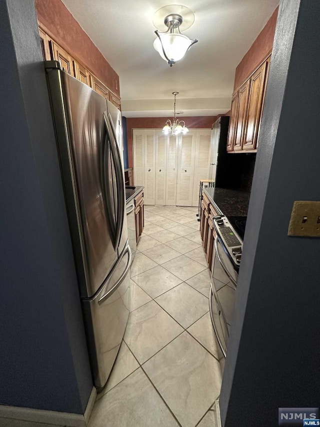 kitchen featuring light tile patterned floors, a notable chandelier, and appliances with stainless steel finishes