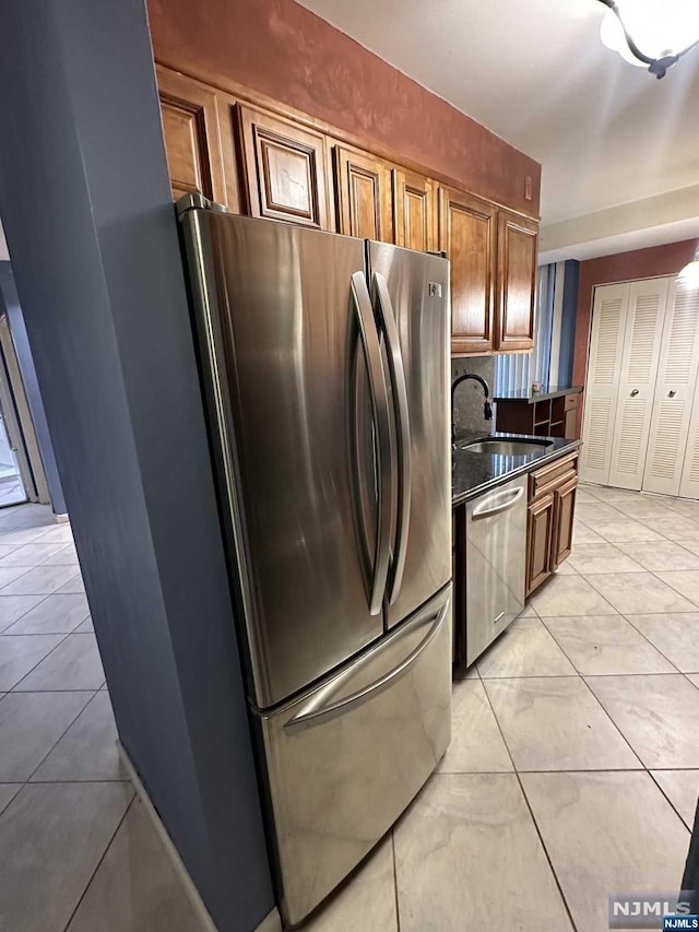 kitchen featuring light tile patterned floors, stainless steel appliances, tasteful backsplash, and sink