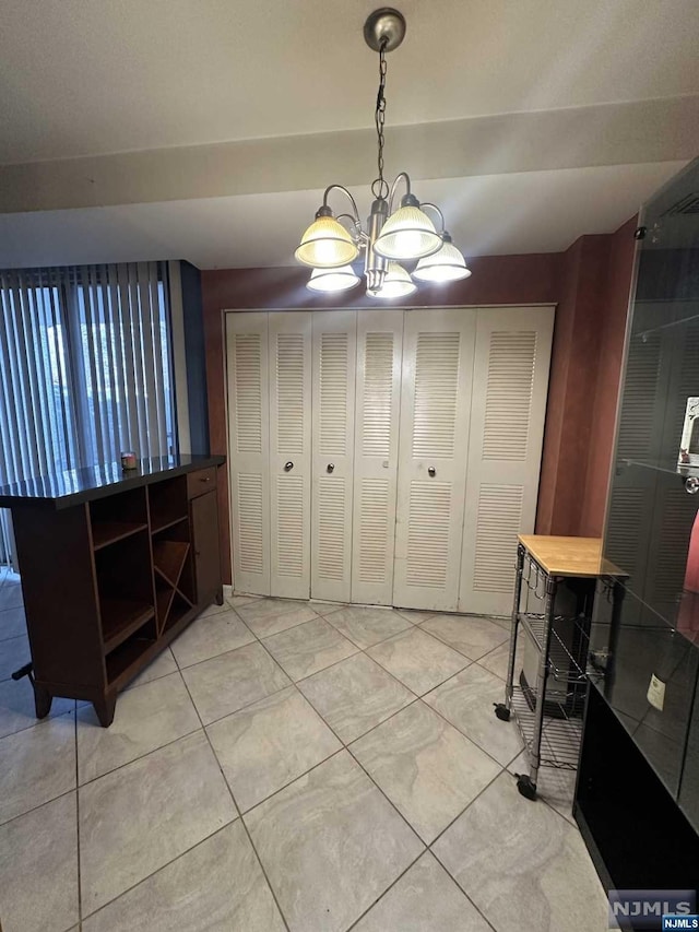 dining area with light tile patterned floors and an inviting chandelier