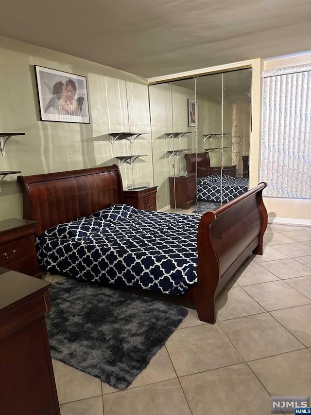 tiled bedroom with a closet