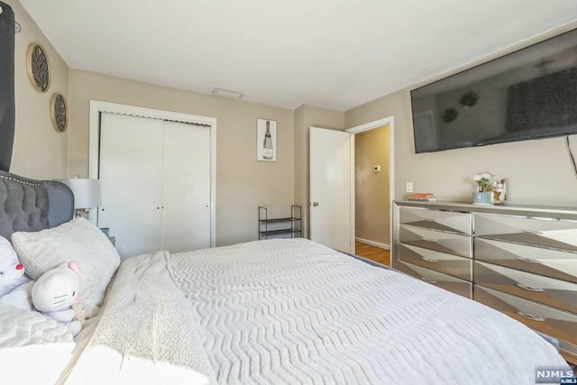 bedroom with a closet and hardwood / wood-style floors