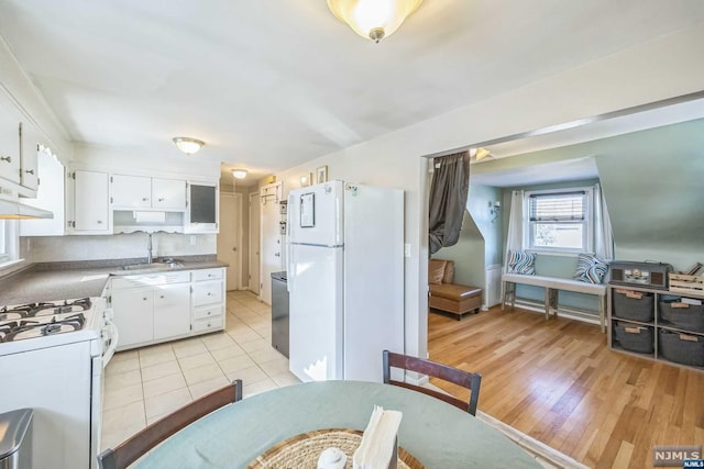 kitchen featuring white appliances, white cabinets, sink, range hood, and light hardwood / wood-style floors