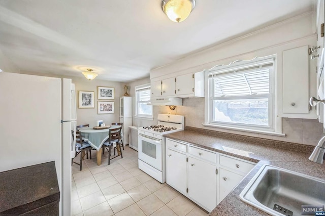 kitchen with sink, light tile patterned floors, tasteful backsplash, white appliances, and white cabinets