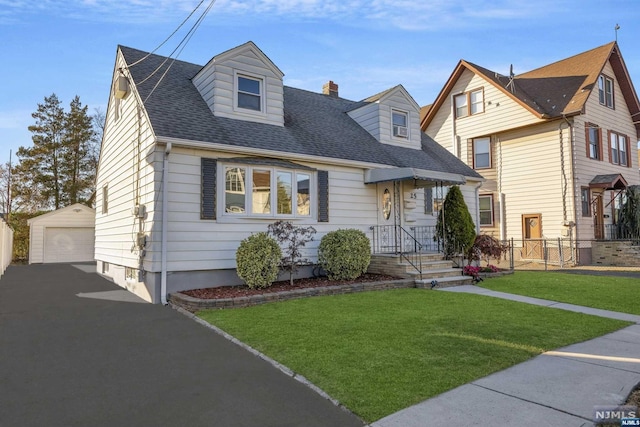 view of front of property featuring a garage, an outdoor structure, and a front yard