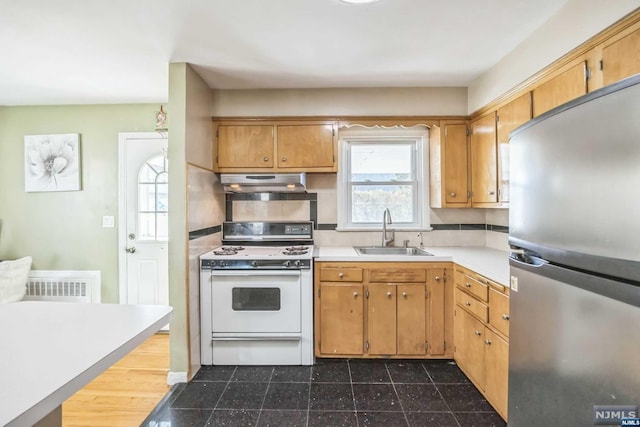 kitchen featuring stainless steel refrigerator, sink, and white range with gas cooktop