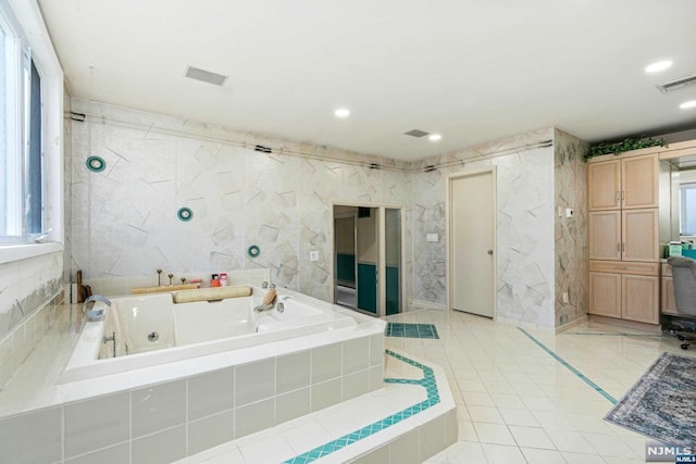 bathroom featuring tile walls and tiled bath